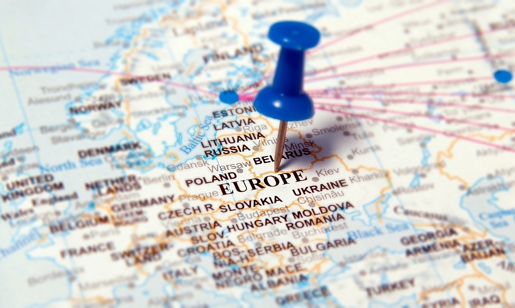Eine Zwecknadel ist auf einer Landkarte auf Europa gepinnt.  