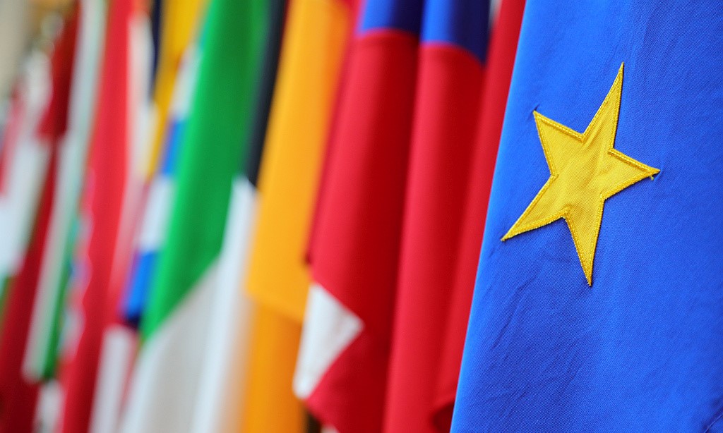 Ausschnitt der Flaggen Europas, im Vordergrund ist ein Stern der europäischen Flagge. 