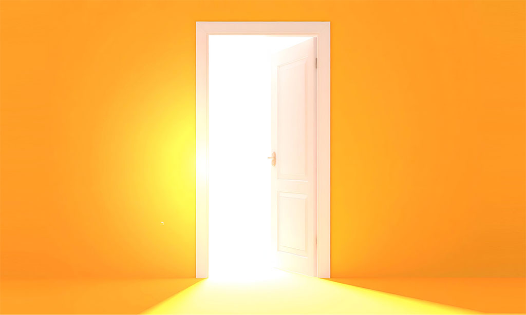 Bild einer offenen Tür, durch die helles Licht in einen gelben Raum strömt. Das Bild symbolisiert Neuanfang, Hoffnung, Chance. 